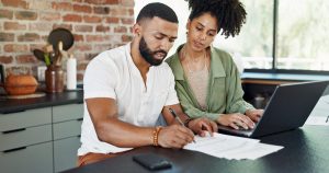 Un couple examine des documents de rachat de prêt autour d’une table.