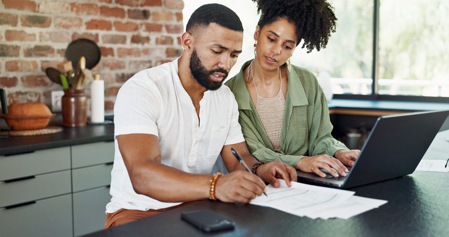 Un couple examine des documents de rachat de prêt autour d’une table.